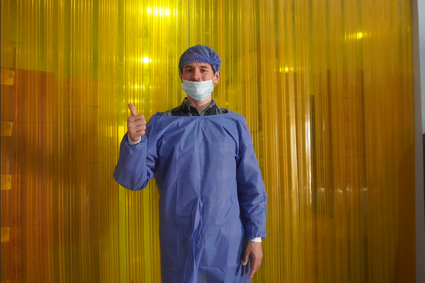 A man in a blue outfit at a cocoa factory