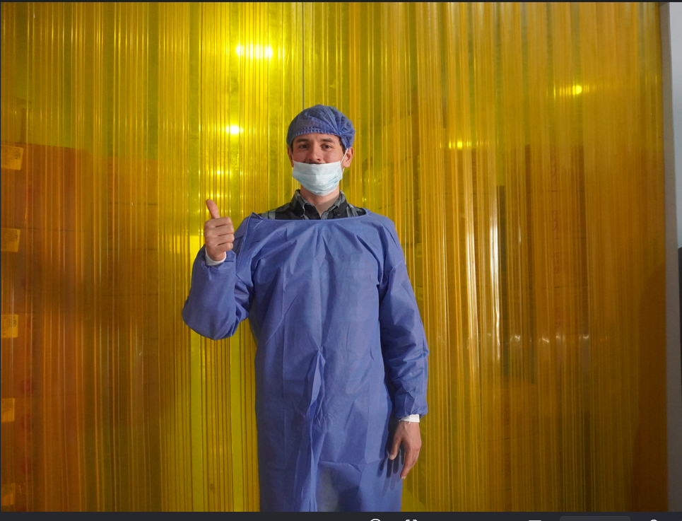 A man in a blue outfit at a cocoa factory